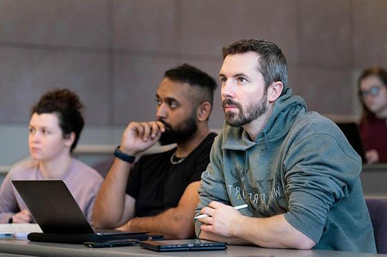 Photo of a group of Chatham students in a lecture hall, listening to class.